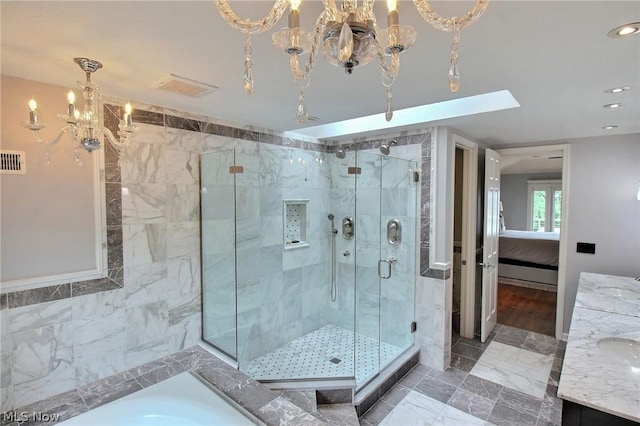 bathroom with vanity, shower with separate bathtub, and a chandelier