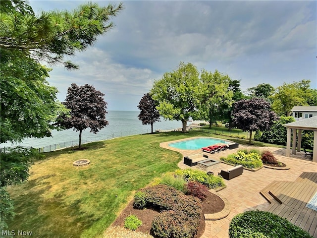 view of pool featuring a water view, a yard, an outdoor fire pit, and a patio area