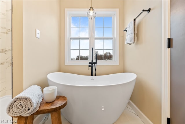 bathroom with a healthy amount of sunlight, tile patterned flooring, and a bathtub