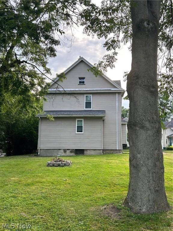 rear view of property featuring a yard