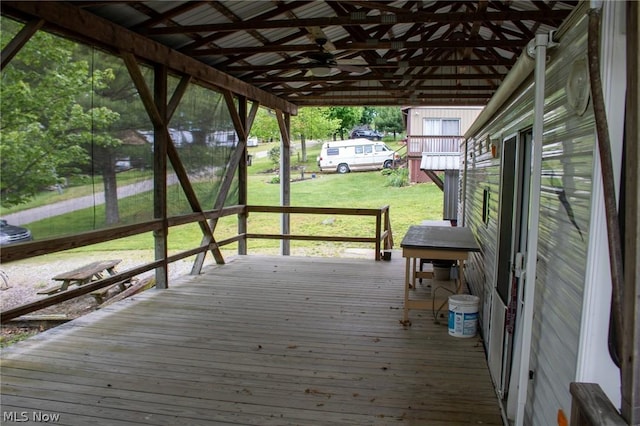 wooden terrace featuring a yard and a carport