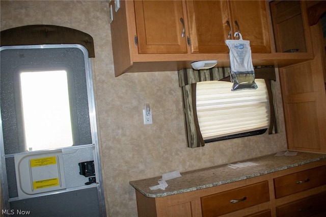 kitchen with stone countertops and brown cabinetry