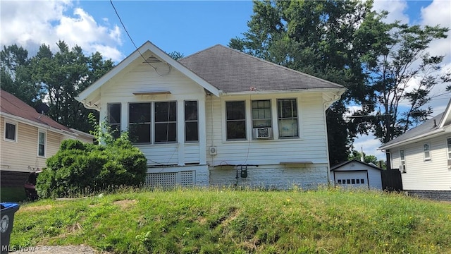 view of front of home featuring a garage, an outbuilding, and roof with shingles