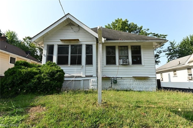 back of property with cooling unit and a yard