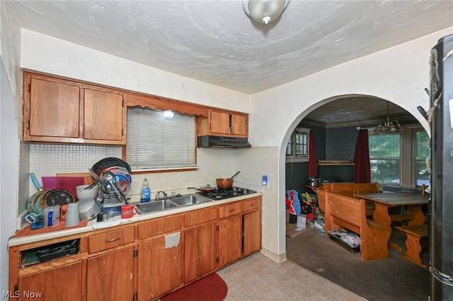 kitchen with decorative backsplash, sink, and black gas cooktop