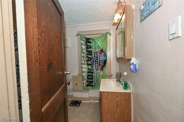 bathroom featuring vanity, crown molding, and a textured ceiling