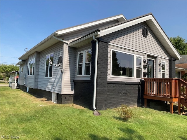 rear view of property with a yard and a wooden deck