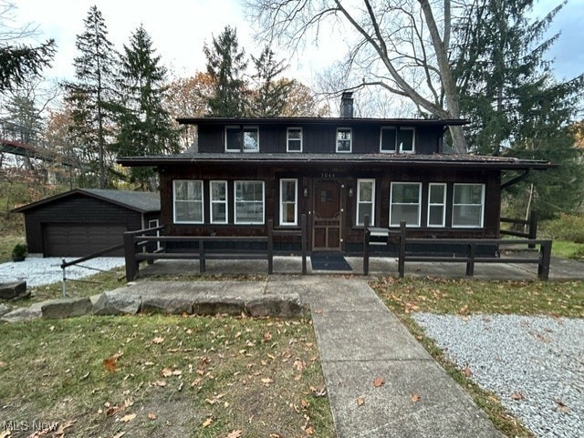 view of front of house with an outdoor structure, a porch, and a garage