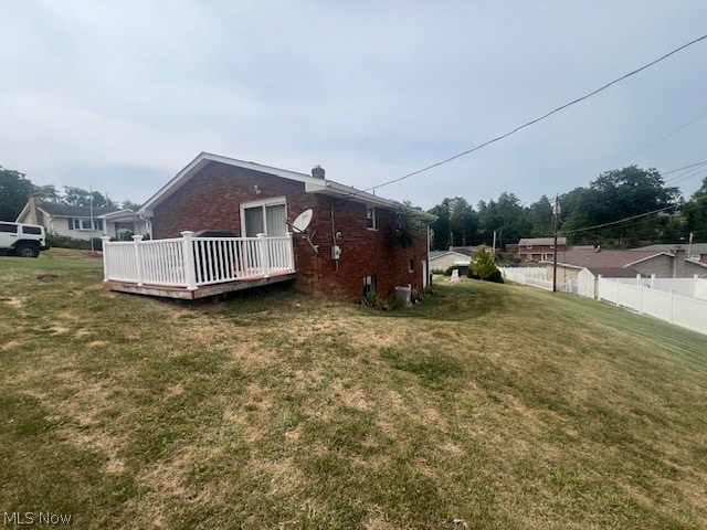 exterior space featuring a deck and a lawn