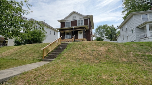 view of front of property featuring covered porch and a front yard