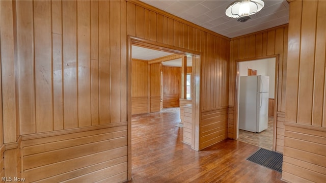 hall featuring wood walls and hardwood / wood-style flooring