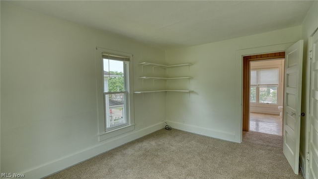 carpeted spare room featuring a healthy amount of sunlight