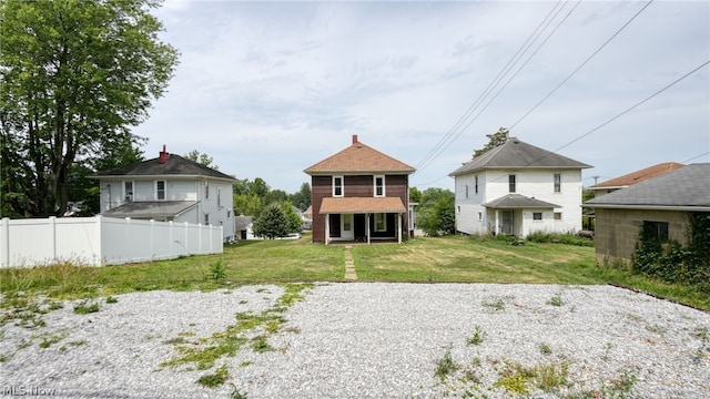 rear view of property featuring a yard