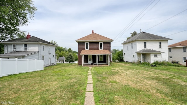 rear view of house featuring a yard