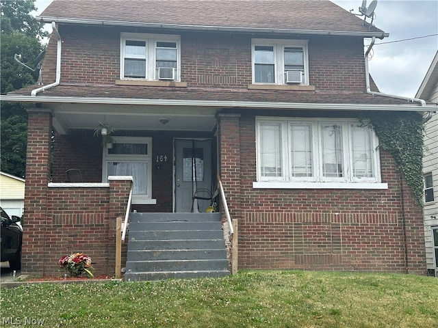 view of front of property featuring a front lawn and cooling unit