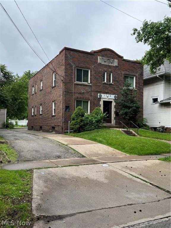 view of front facade featuring a front yard and brick siding