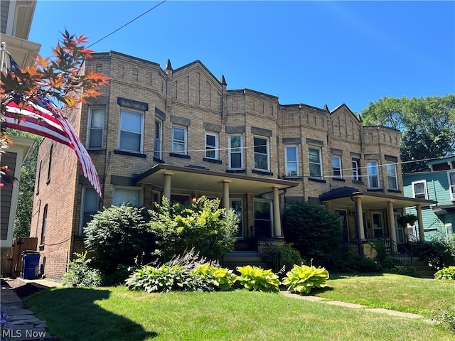 multi unit property with a front yard and covered porch