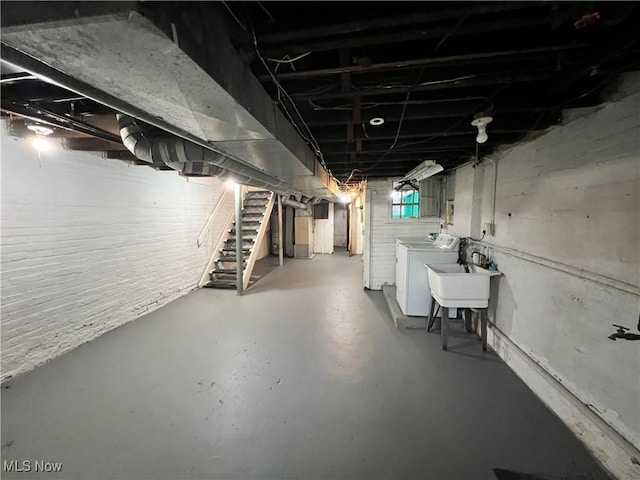 basement featuring washer and clothes dryer and sink