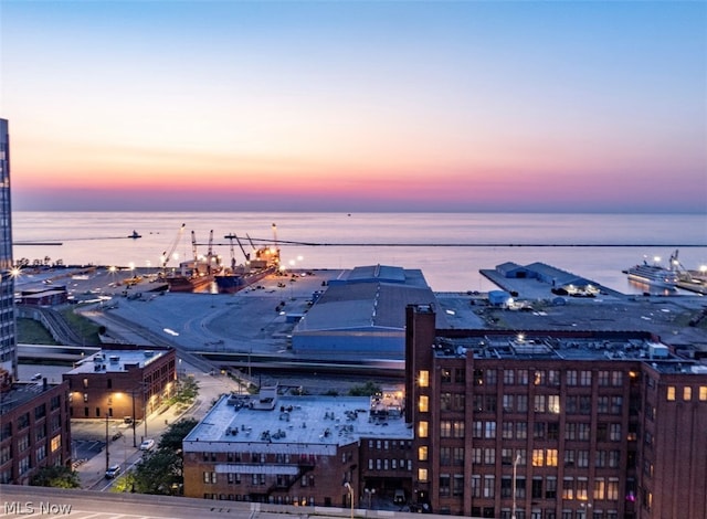 aerial view at dusk featuring a water view