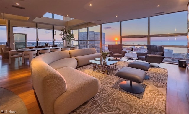 interior space featuring wood-type flooring, a water view, and expansive windows