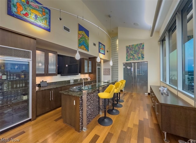 kitchen featuring dark brown cabinetry, a center island, and light hardwood / wood-style flooring