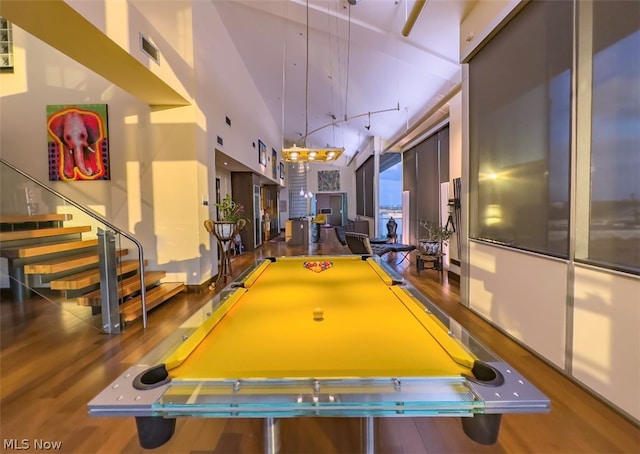 rec room featuring pool table, hardwood / wood-style flooring, and a towering ceiling