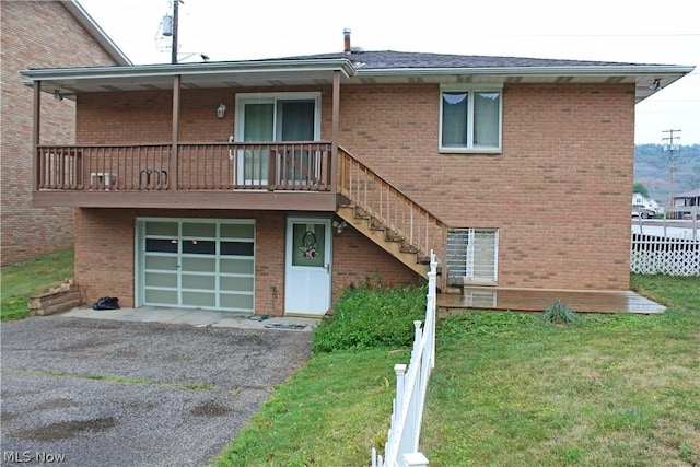 exterior space with brick siding, an attached garage, and a front yard