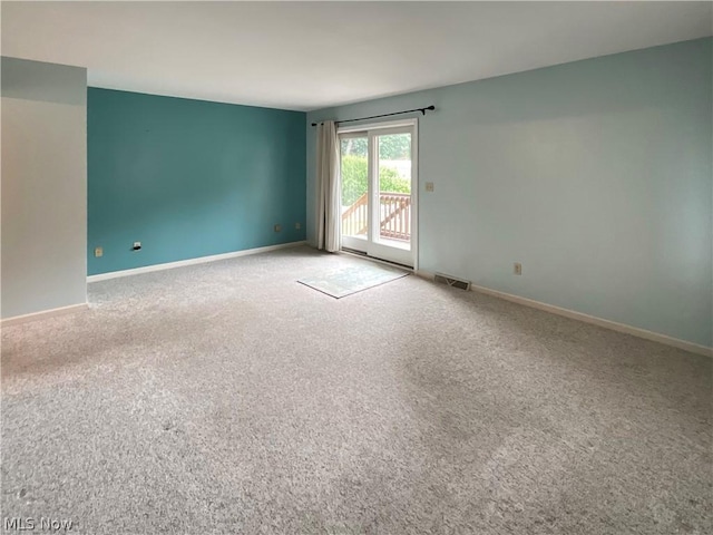 carpeted empty room with visible vents and baseboards