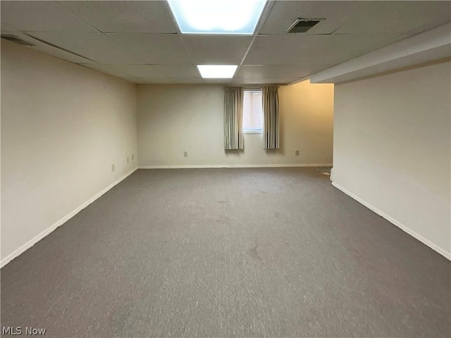 unfurnished room with carpet floors, a drop ceiling, visible vents, and baseboards