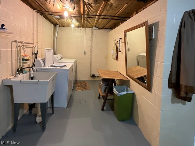 clothes washing area featuring laundry area, separate washer and dryer, and a sink