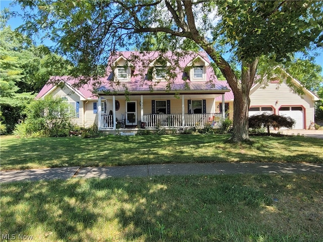 new england style home featuring a garage, a front yard, and covered porch