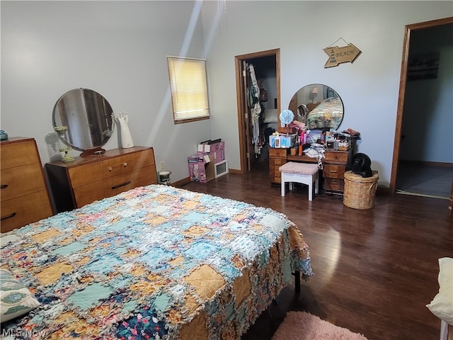 bedroom with dark hardwood / wood-style flooring, a closet, and a walk in closet