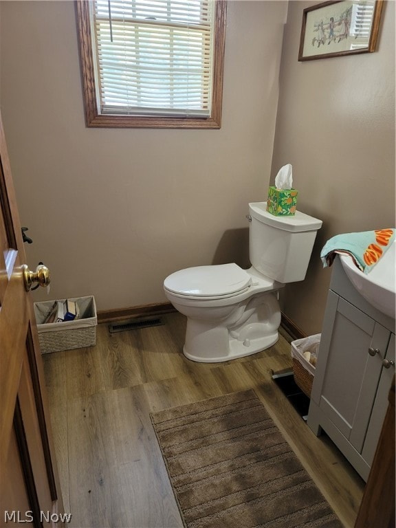 bathroom with vanity, toilet, and hardwood / wood-style floors