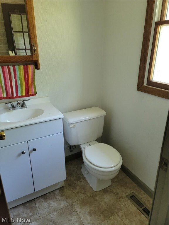 bathroom with vanity, toilet, and tile patterned floors