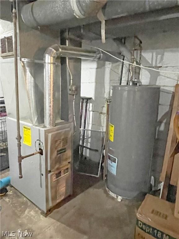 utility room featuring heating unit and water heater