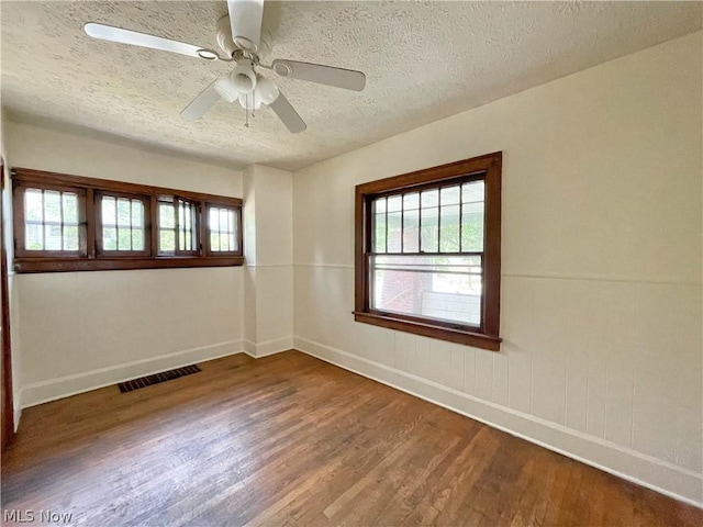 unfurnished room with hardwood / wood-style flooring, a textured ceiling, and ceiling fan