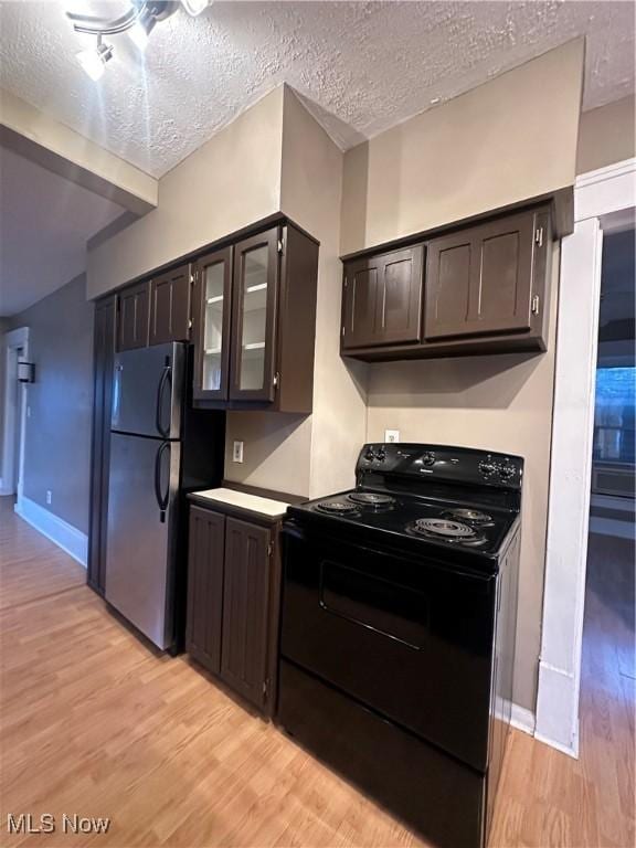 kitchen with black range with electric stovetop, dark brown cabinets, stainless steel refrigerator, and light wood-type flooring