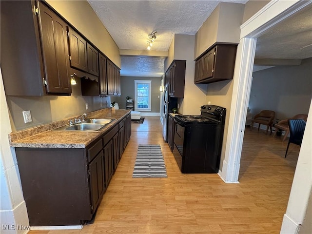 kitchen featuring light hardwood / wood-style floors, sink, a textured ceiling, and black / electric stove