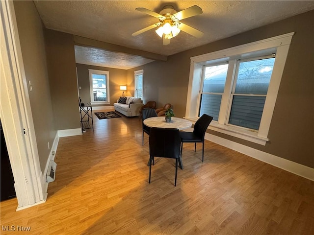 dining room featuring ceiling fan, hardwood / wood-style floors, and a textured ceiling