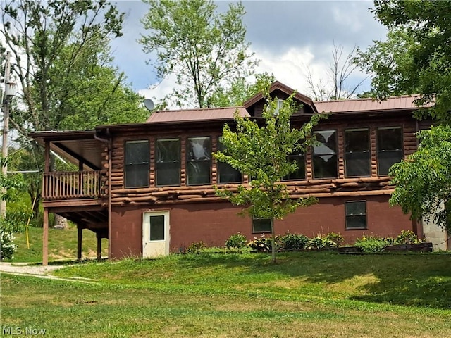 back of house with metal roof, a yard, log exterior, and stucco siding