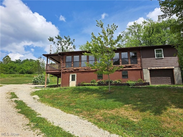 exterior space with an attached garage, driveway, a deck, and a front yard