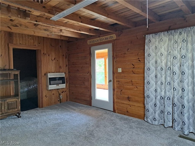 unfurnished living room with wood ceiling, beamed ceiling, heating unit, carpet flooring, and wood walls