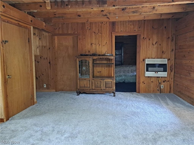 living room with wooden walls, light colored carpet, and heating unit