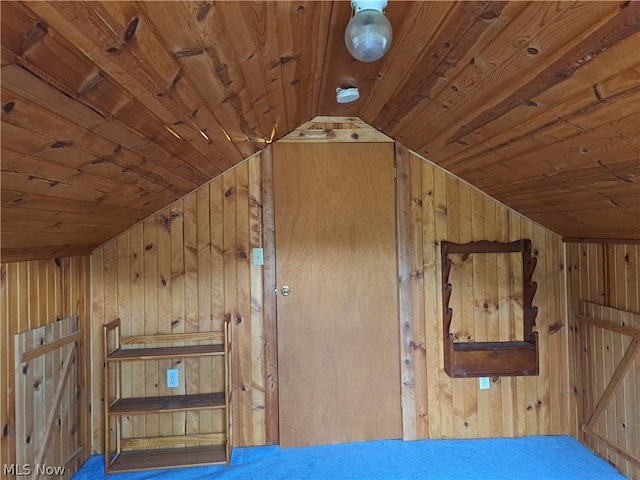 interior space featuring lofted ceiling, wooden ceiling, and wood walls