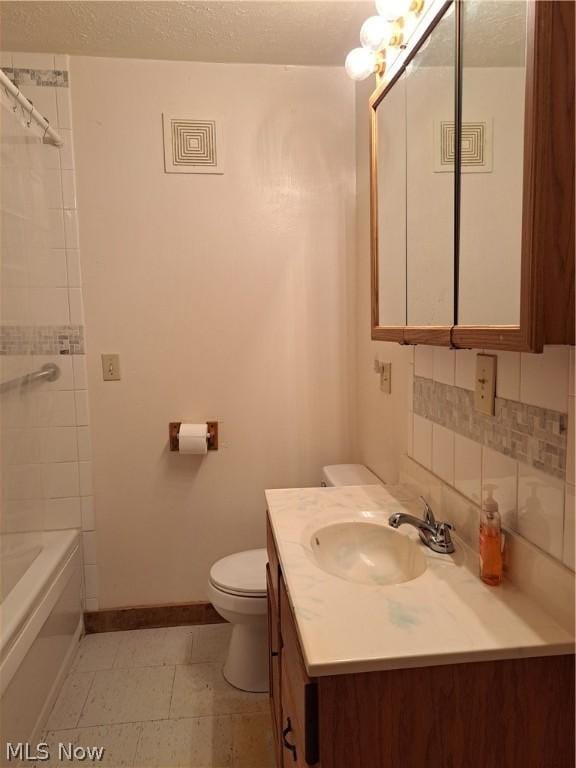 bathroom featuring tasteful backsplash, baseboards, toilet, a textured ceiling, and vanity