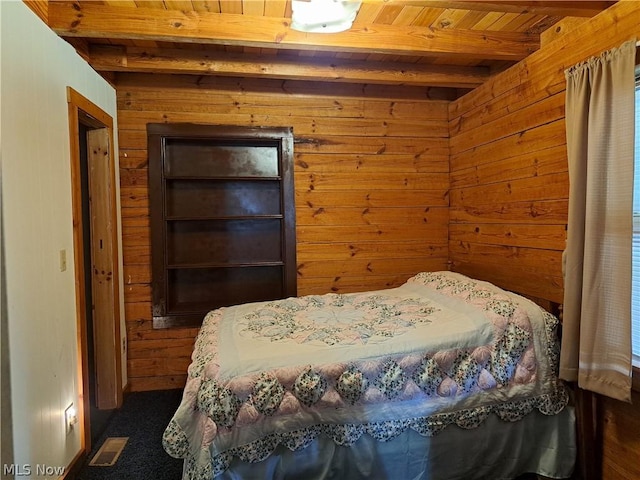 bedroom with wooden ceiling, wooden walls, visible vents, and beamed ceiling