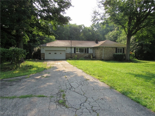 single story home with a garage and a front lawn