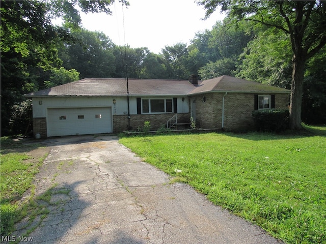 ranch-style house featuring a garage and a front lawn