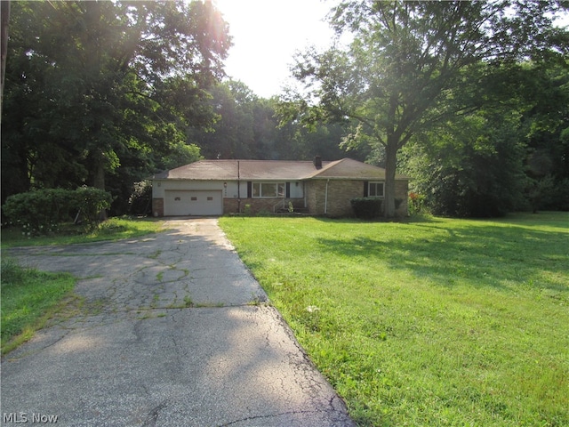 single story home with a garage and a front lawn