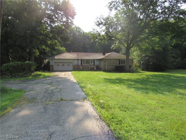 ranch-style home featuring a garage and a front lawn